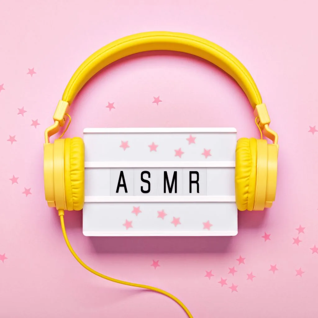 Gele koptelefoon rond een lichtbak met de tekst ASMR