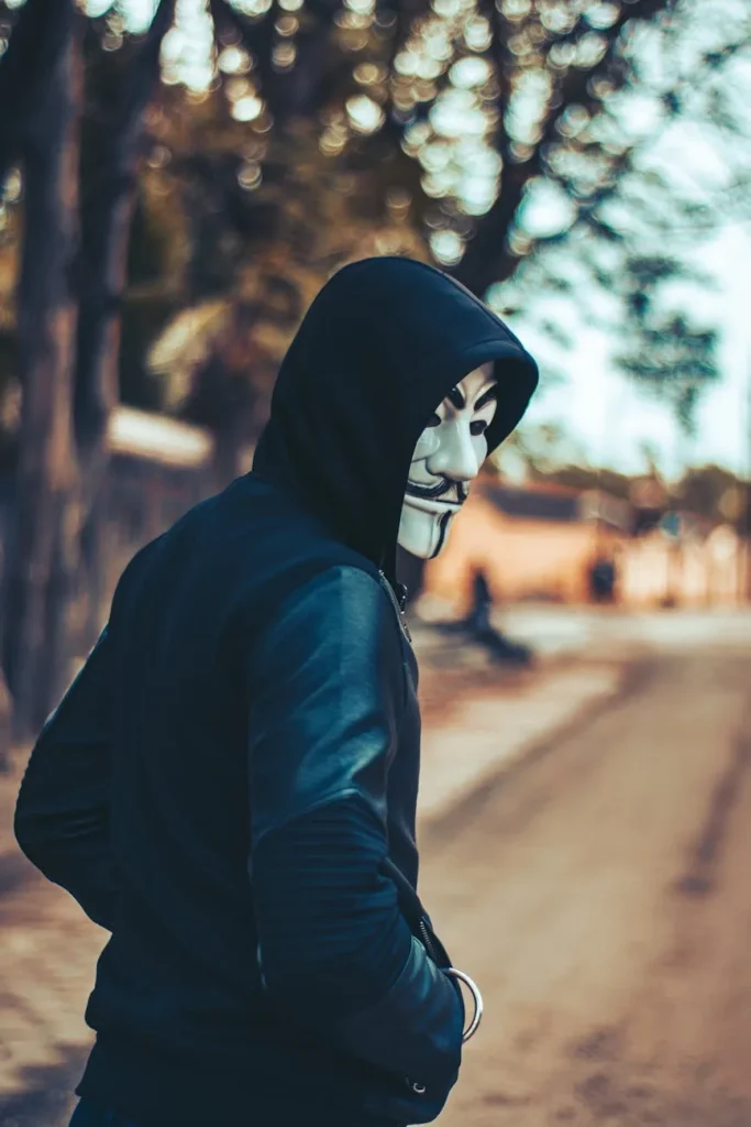 Hombre con sudadera con capucha y máscara de Guy Fawkes