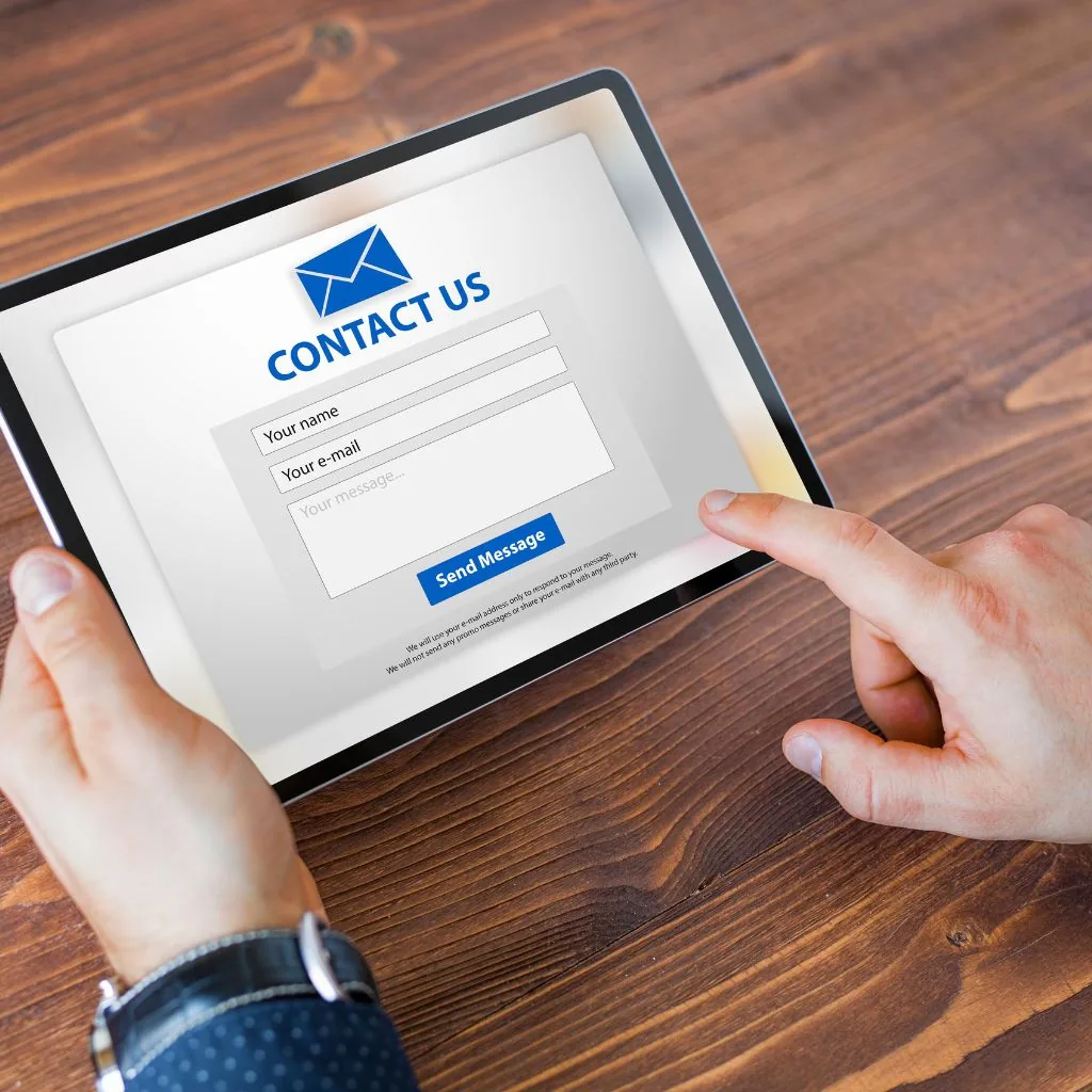 Handen vullen een contactformulier in op een tablet
