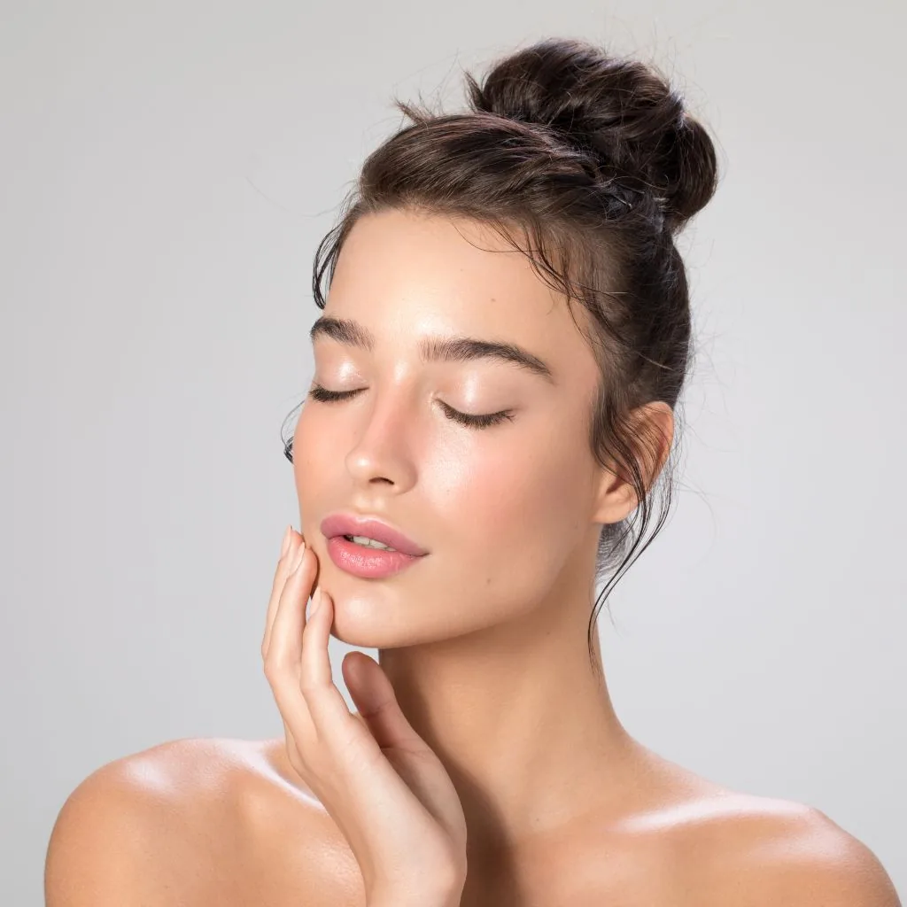 Portrait of a young woman with her eyes closed and a hand on her cheek