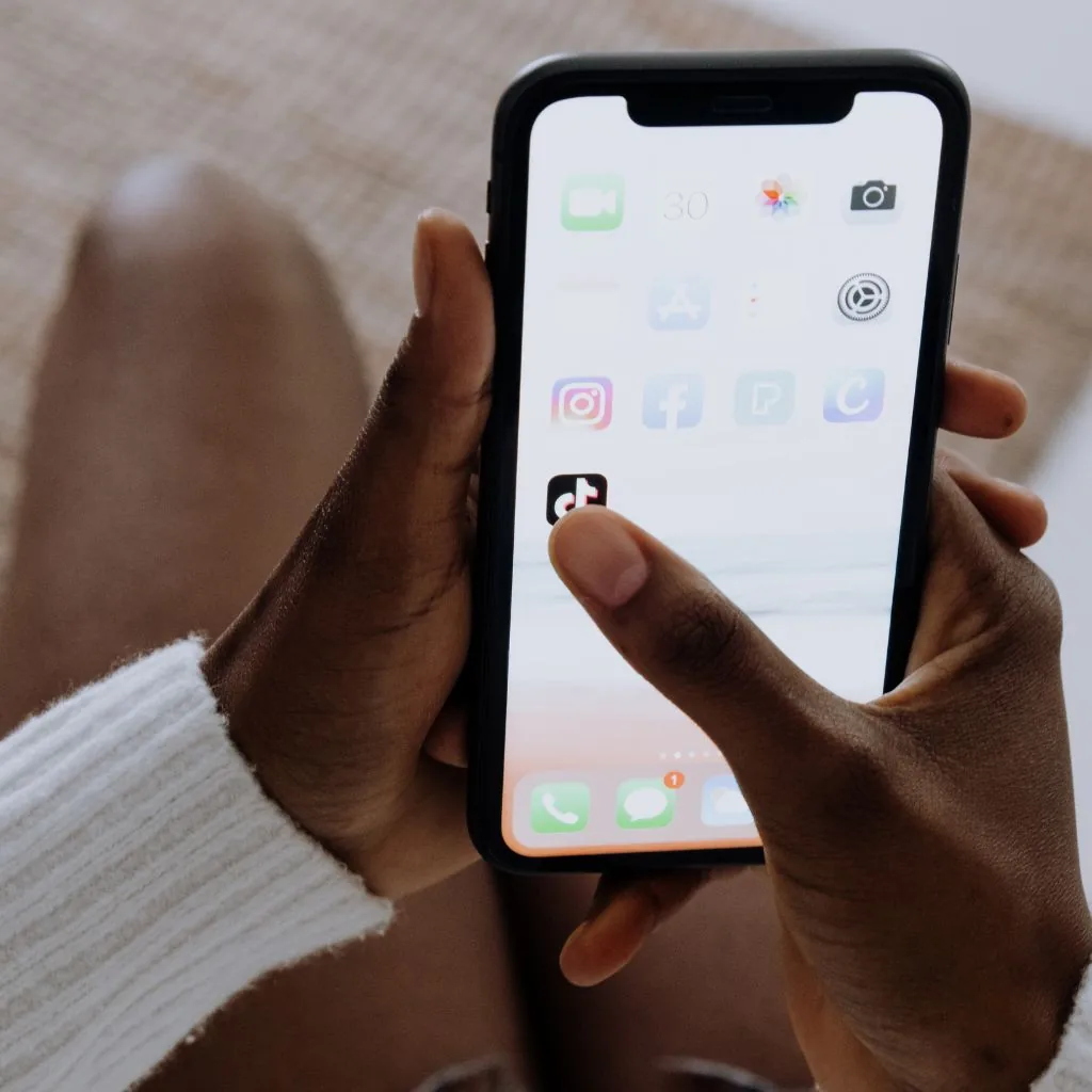 Handen met een smartphone op het startscherm met apps