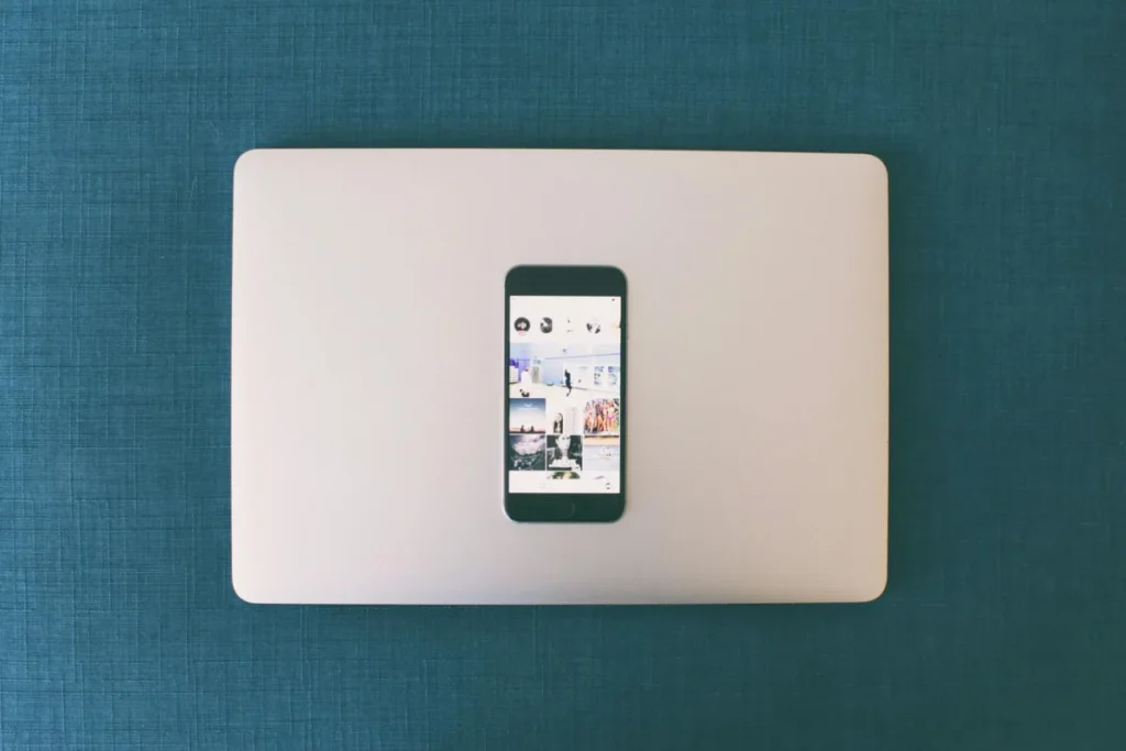 Móvil con un feed de Instagram sobre un portátil cerrado