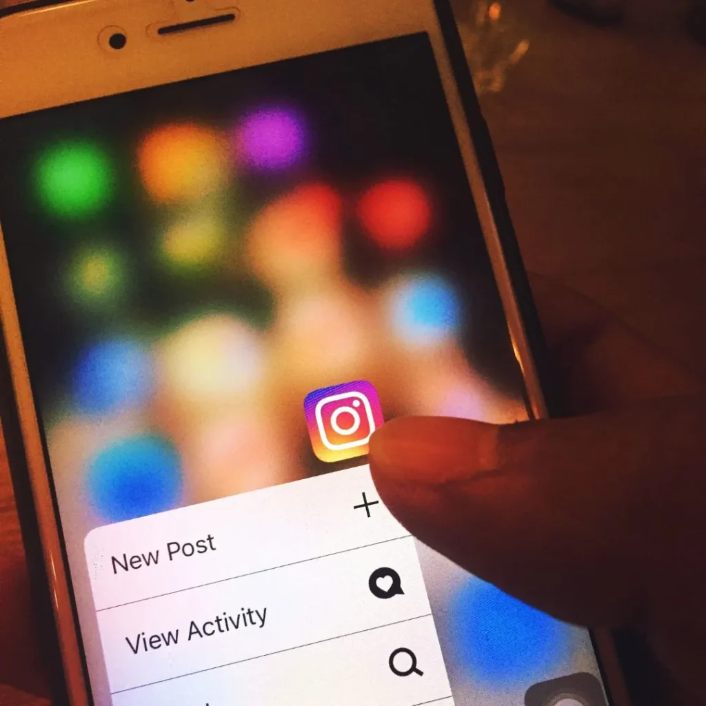 Pouce appuyant sur l'icône Instagram d'un smartphone pour ouvrir son menu de raccourcis